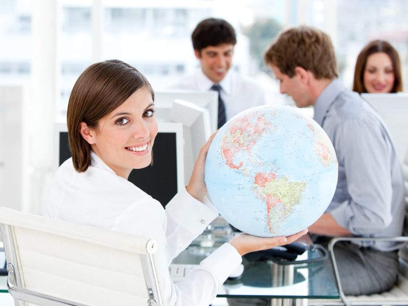 Confident businesswoman holding a globe